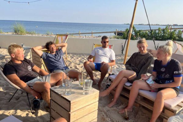 Menschen sitzen an der Strandbar und trinken etwas